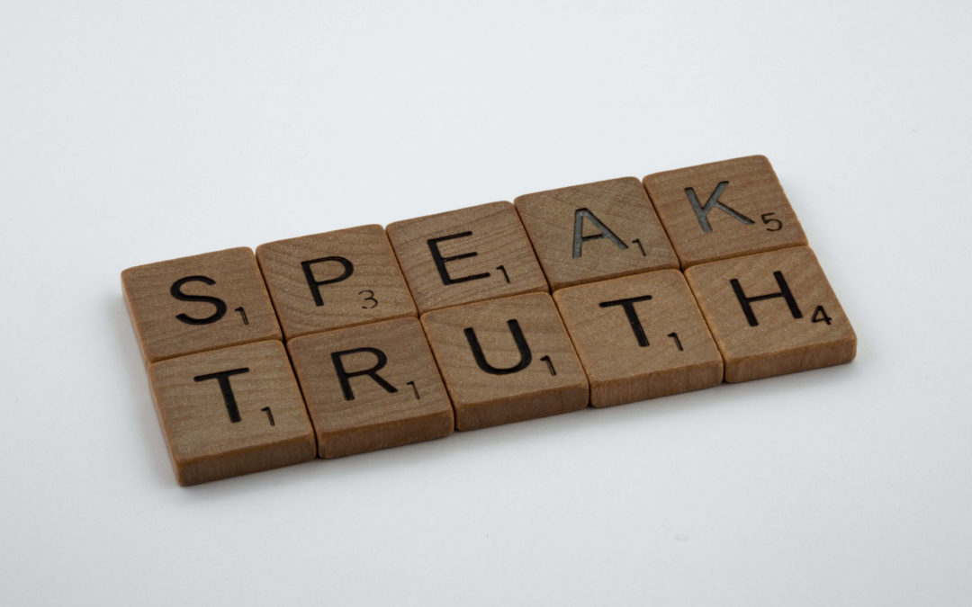 Speak Truth spelled out in Scrabble tiles on white background